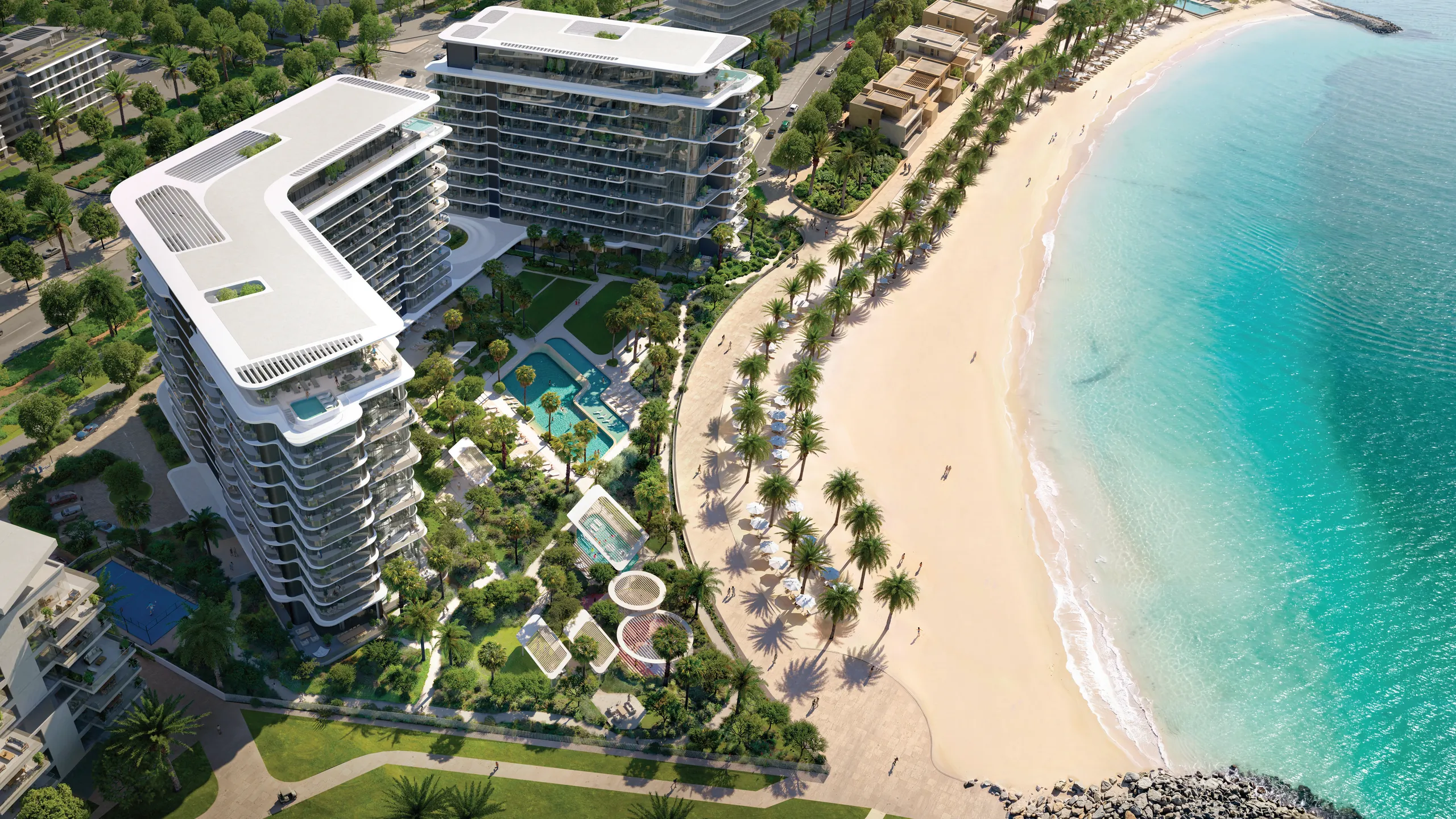 The residences from above: the L-shaped building, gardens and pools, and the curve of the beach