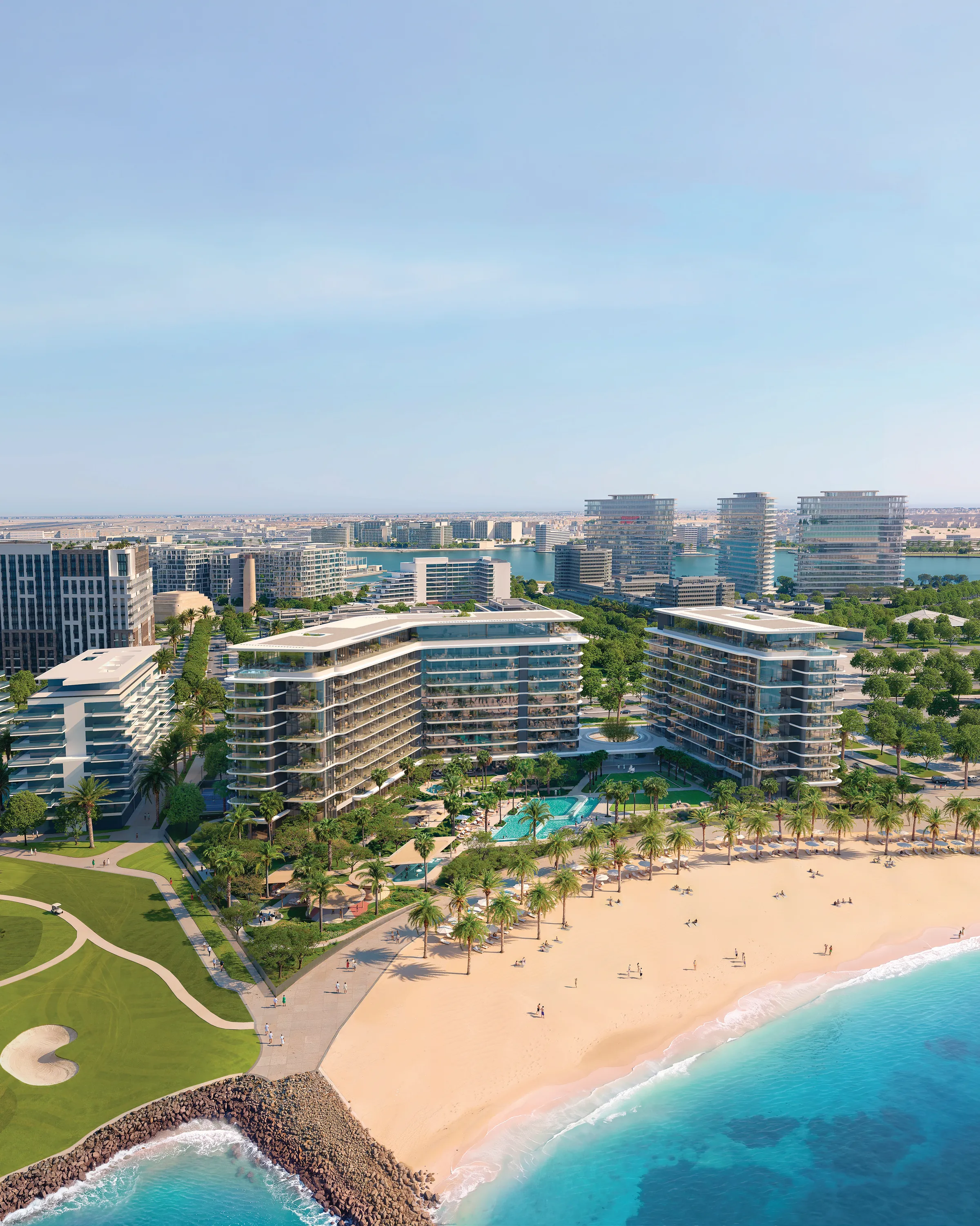 The residences seen from above the sea: three white buildings behind a palm-lined beach, the golf course to the left