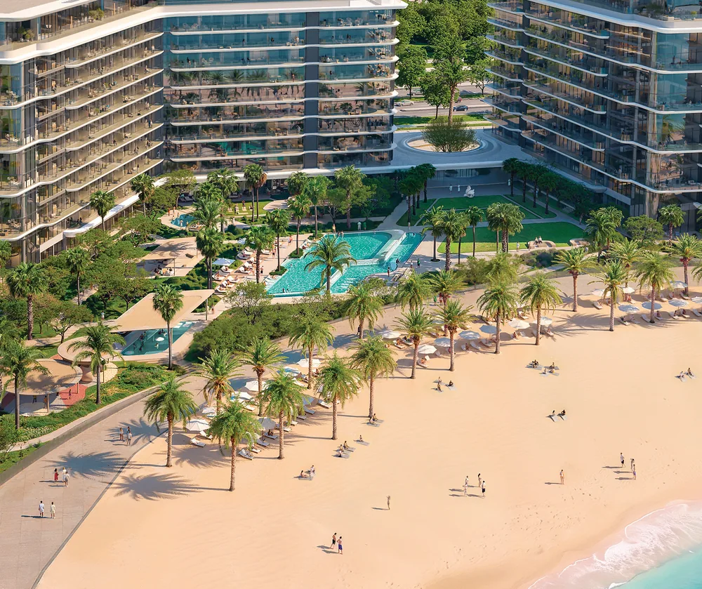 The buildings behind the pools and palms, with the beach in front